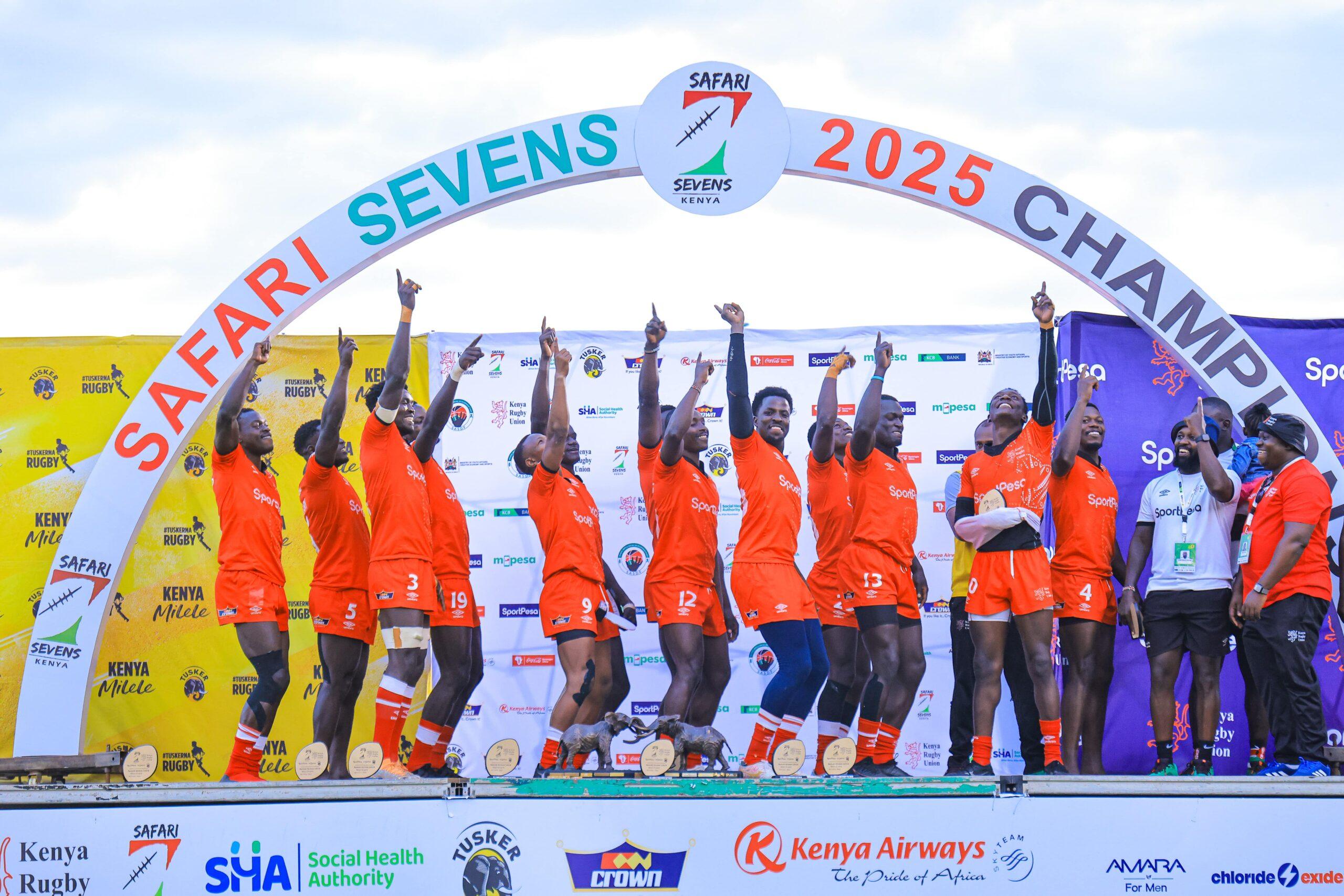 Kenya Shujaa rugby sevens players celebrate their Safari Sevens championship victory on the podium.