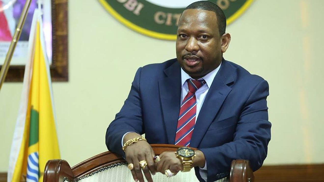 Former Nairobi Governor Mike Sonko seated at a desk wearing a light blue suit.