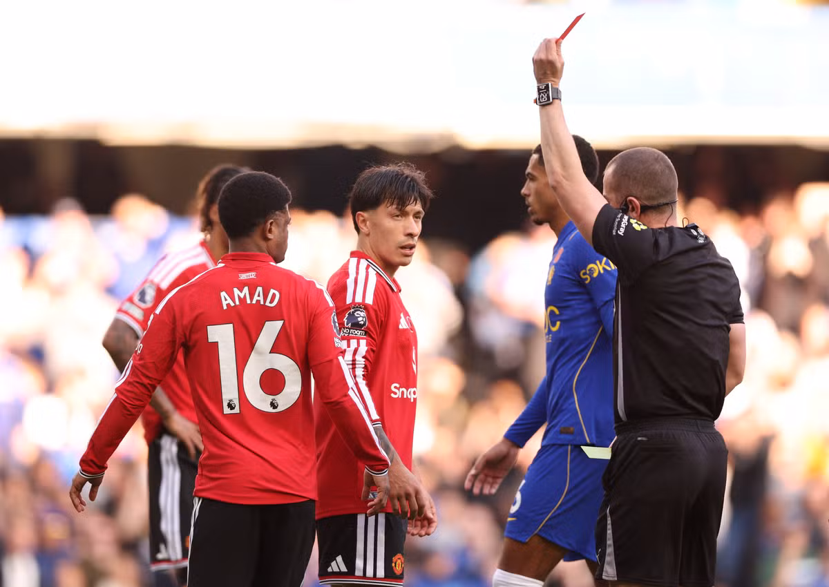 Manchester United players react as a referee raises a card during their Premier League match against Chelsea.